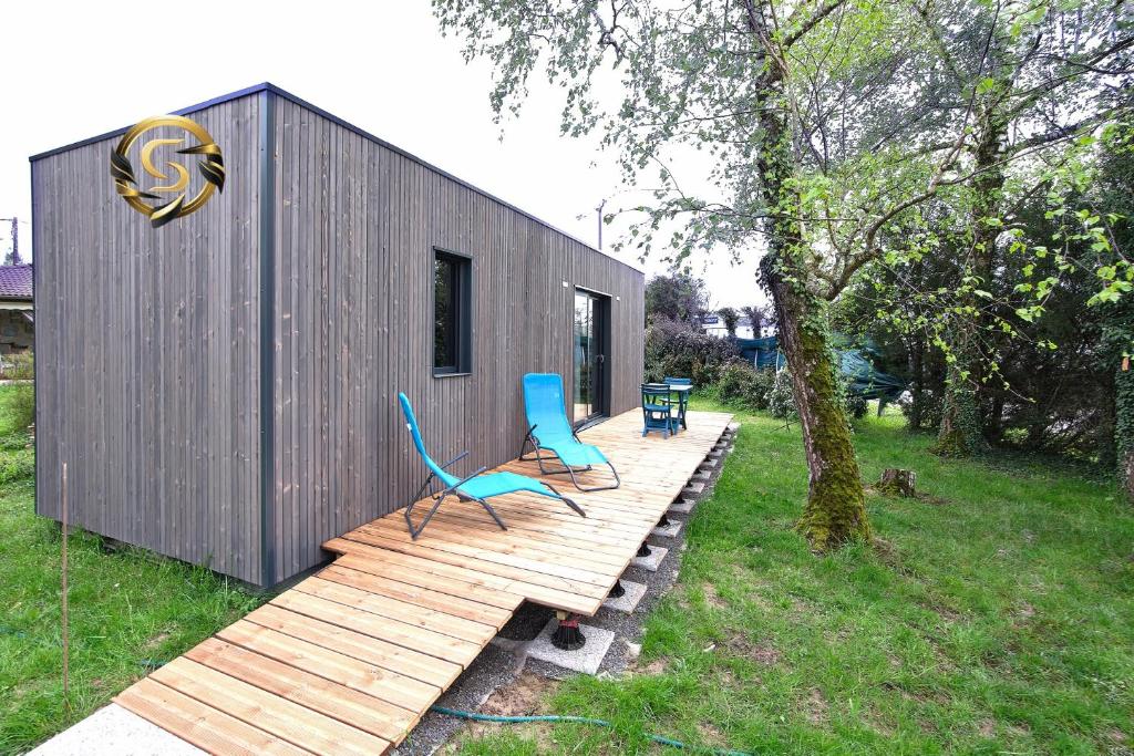 una casa pequeña con 2 sillas en una terraza de madera en Tiny House Saint Cyr sur Menthon, en Saint-Cyr-sur-Menthon