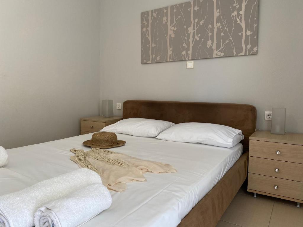 a bed with a hat and towels on it at Bright and cozy apartment near the city center in Zakynthos Town