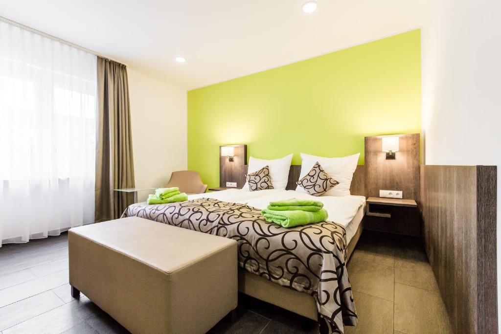 a hotel room with a bed with green towels on it at Zehnthof Apartment WH1 in Pulheim