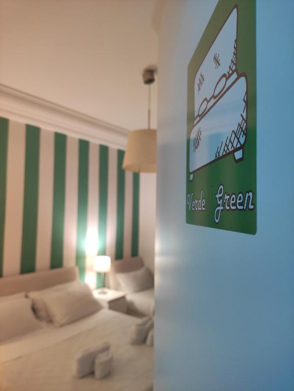 a bedroom with a bed and a green and white striped wall at Palermo Central B&B in Palermo