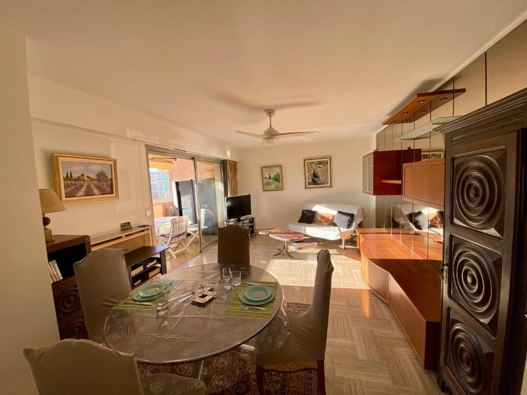 een woonkamer met een glazen tafel en een keuken bij 2P Cagnes Sur Mer- Proximité Plage, Parking in Cagnes-sur-Mer