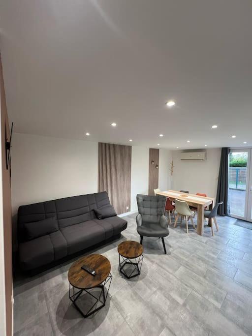 un salon avec un canapé et une table dans l'établissement Maisonnette Le Verger, Lac d'Orient, Nigloland., à La Loge-aux-Chèvres