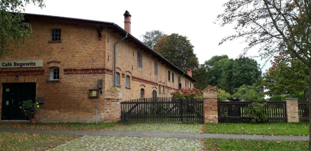 a brick building with a gate in front of it at Große Ferienwohnung in Bugewitz mit Gepflegtem Garten in Bugewitz
