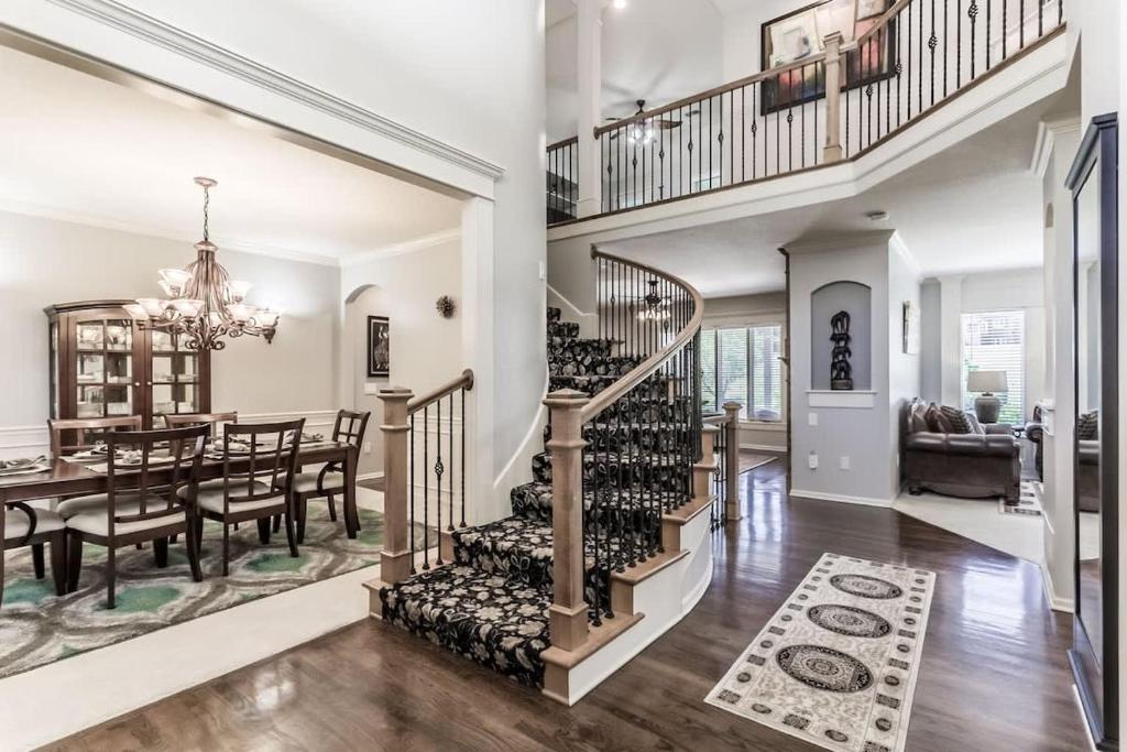 a dining room and kitchen with a spiral staircase in a house at Beautiful relaxing private villa next to a pond smart home and Traeger Grill in Overland Park