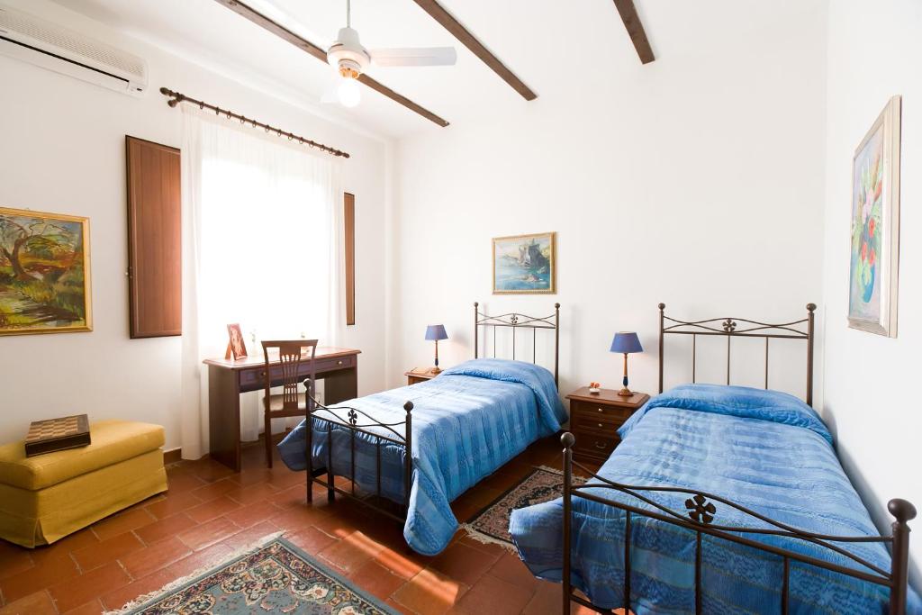 a bedroom with two beds and a yellow chair at Orange Park - Agriturismo in Misterbianco
