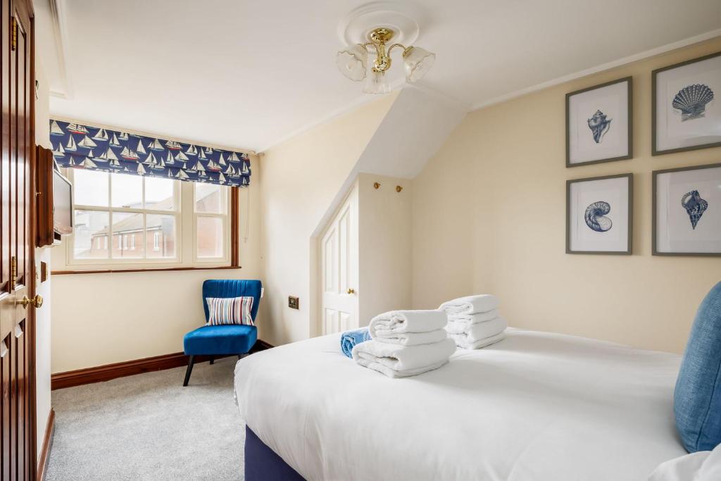 1 dormitorio con 1 cama y 1 silla azul en The Old Townhouse - Room 3, en Poole