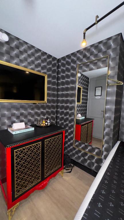 y baño con espejo grande y tocador rojo. en Hotel Helene, en Medellín