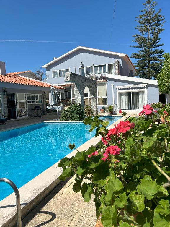 a house with a swimming pool and some flowers at MAR VERDE - Parede-Cascais in Parede