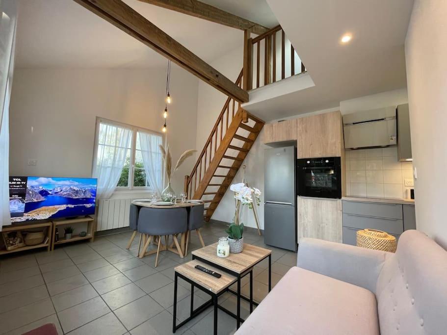 un salon avec un canapé et une table et une cuisine dans l'établissement Charmante Maisonnette - 5 min du Pôle Hippique de Saint-Lô, à Saint-Pierre-de-Semilly