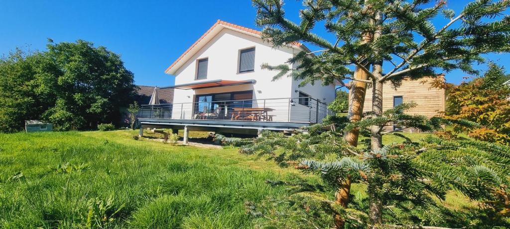 Casa blanca con balcón y árbol en La Renouée, en Gérardmer