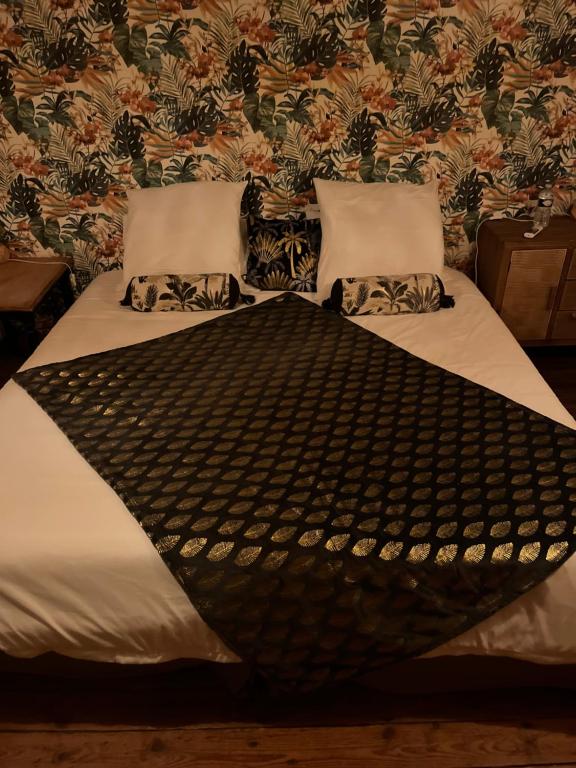 a bed with two pillows on it in a room at Le Ginkgo in Caulnes