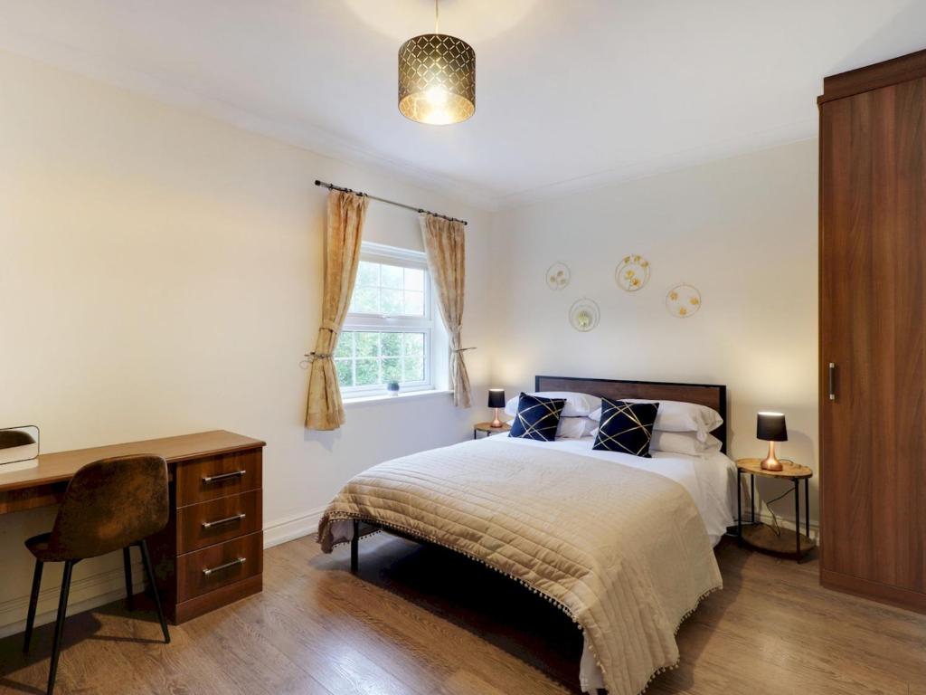 Schlafzimmer mit einem Bett, einem Schreibtisch und einem Fenster in der Unterkunft Spacious retreat in the heart of Tunbridge Wells Pass the Keys in Royal Tunbridge Wells