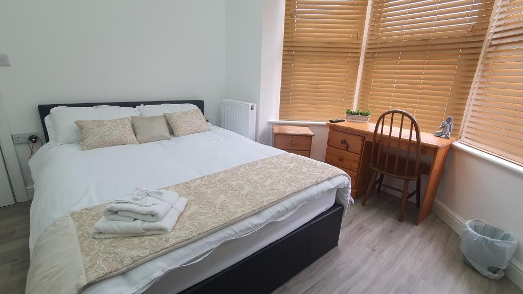 1 dormitorio con cama, escritorio y silla en Highfield House, en Wellingborough