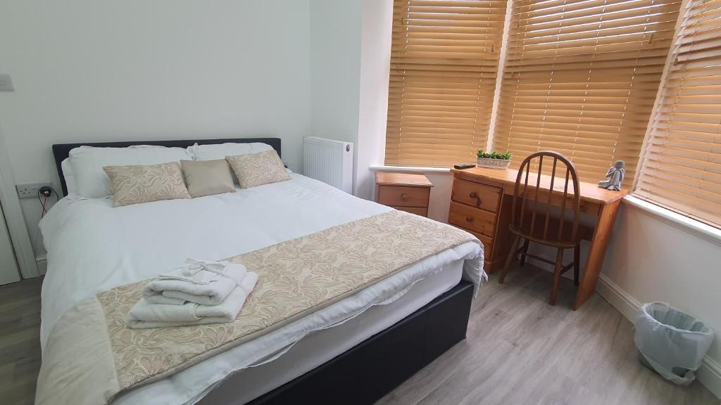 a bedroom with a bed and a desk and a chair at Highfield House in Wellingborough