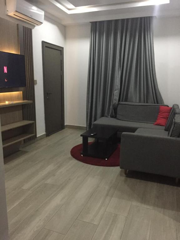 uma sala de estar com um sofá e uma televisão em Eureka Luxury Apartment em Gwarinpa