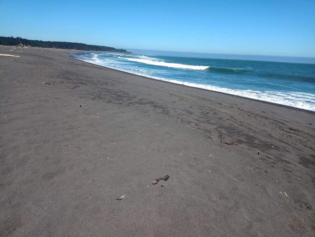 a beach with a few footprints in the sand at Cabañas Las Olas in Constitución