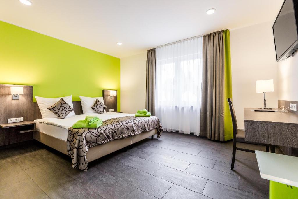 a hotel room with a bed with a green wall at Zehnthof Apartment WH2 OG in Pulheim