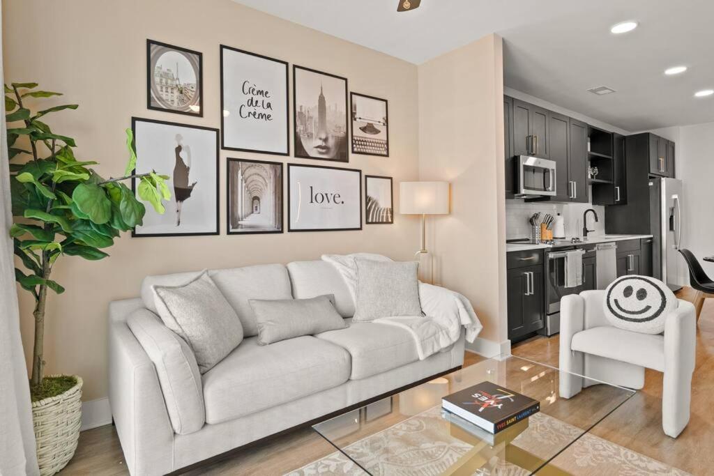a living room with a white couch and a kitchen at Luxurious Urban Retreat with Amazing Amenities in Tampa