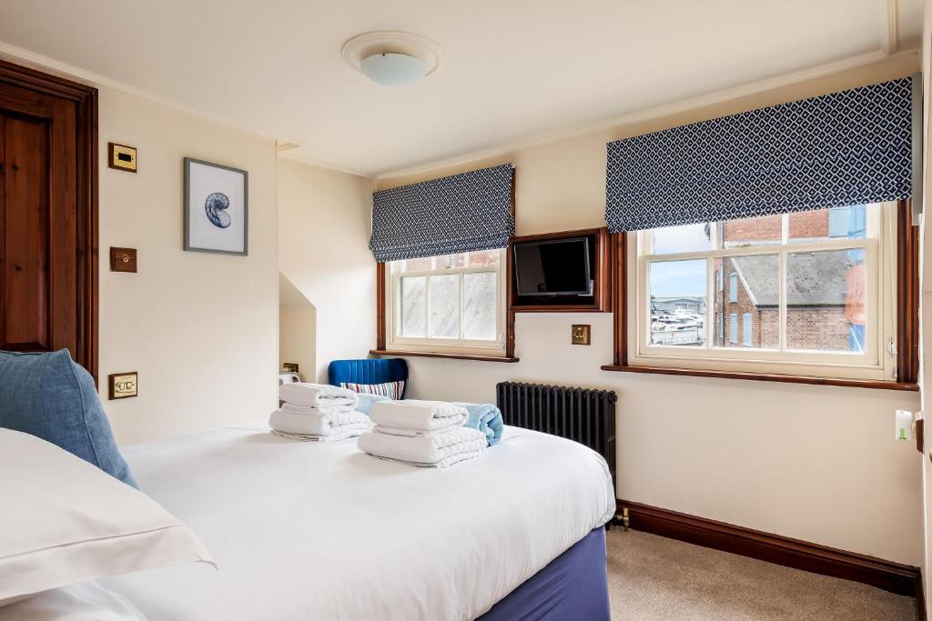 2 Betten in einem Zimmer mit 2 Fenstern in der Unterkunft The Old Townhouse - Room 4 in Poole