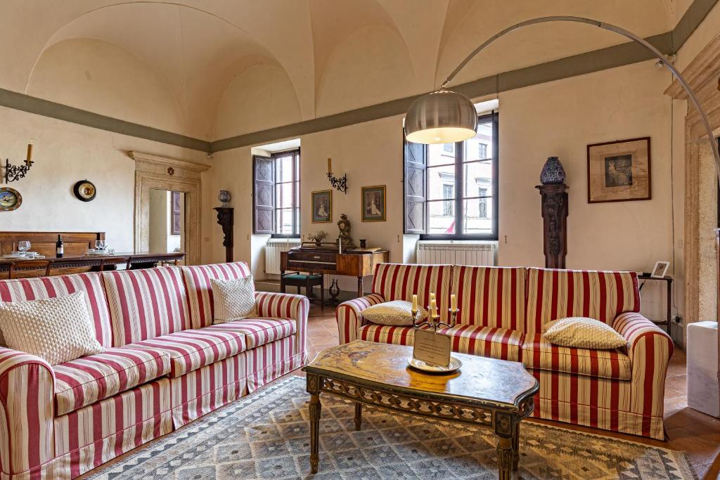 uma sala de estar com dois sofás e uma mesa em Palazzo Costanti - A 8 minuti dalle terme em San Quirico dʼOrcia