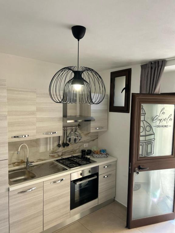 a kitchen with a stove and a chandelier at La Cupola - casa vacanze n 10 in Termini Imerese