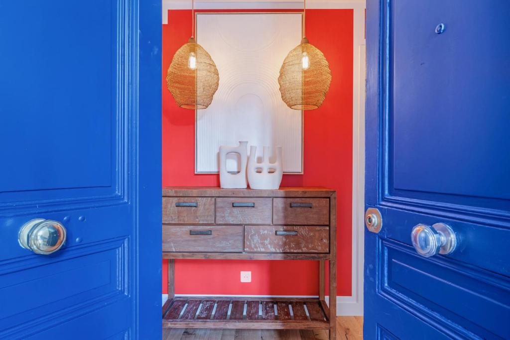 a room with blue doors and a dresser with a mirror at Soubise in Paris