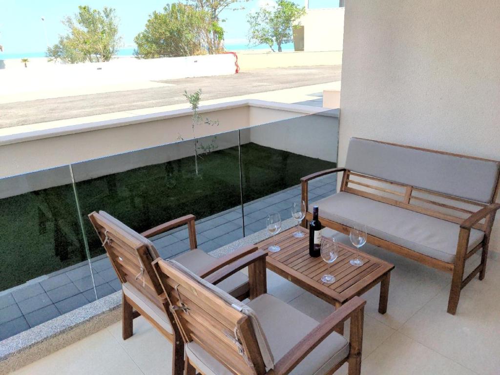 een balkon met 2 stoelen en een tafel met wijnglazen bij Ferienwohnung in Nin mit Großer Terrasse in Nin