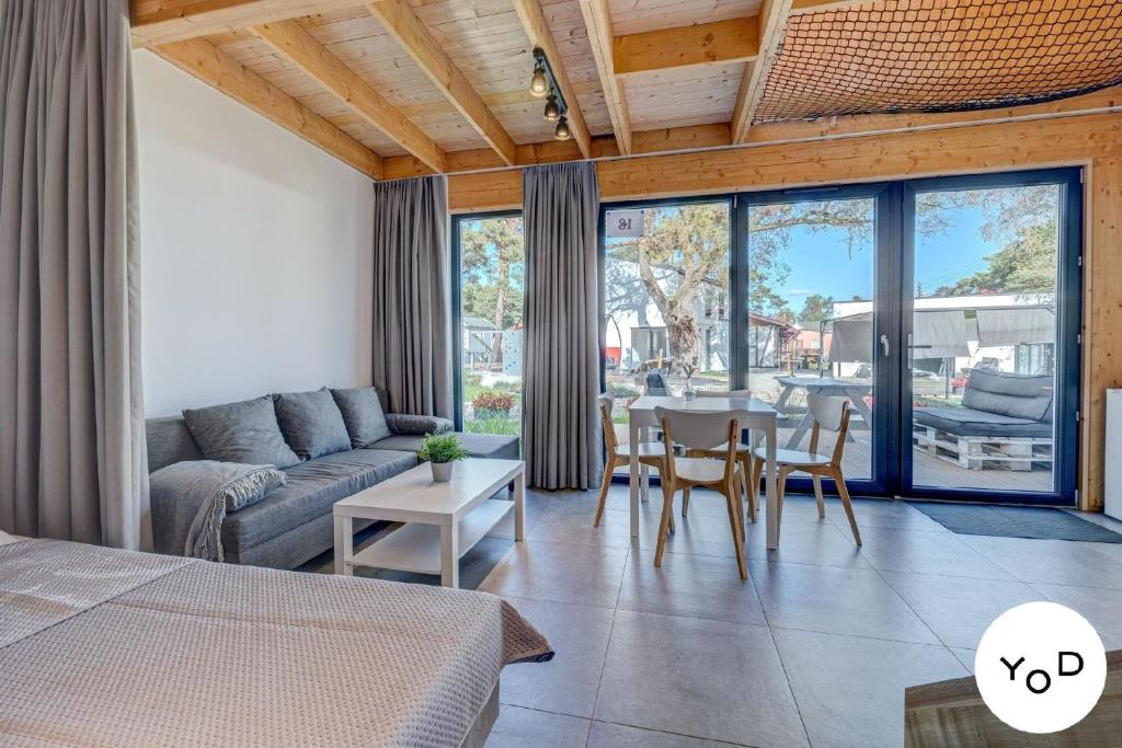 a living room with a couch and a table with chairs at Nettes Ferienhaus in Pustkowo mit Eigener Terrasse in Pustkowo