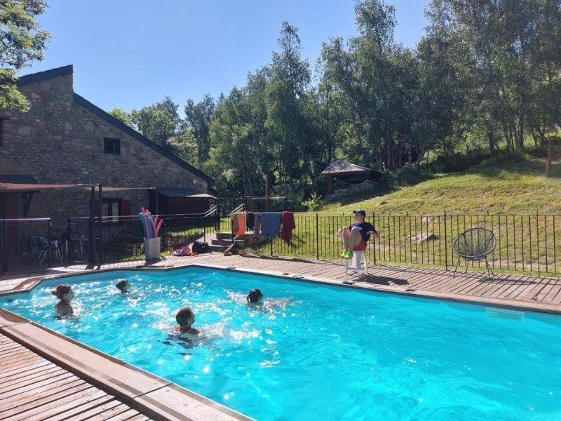 a group of people swimming in a swimming pool at Orri de Planès in Planès