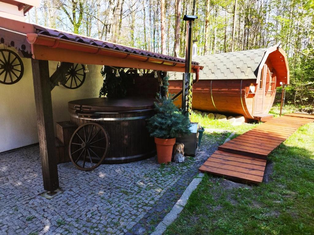 a large hot tub sitting next to a cabin at Leśne Zacisze in Głogów Małopolski