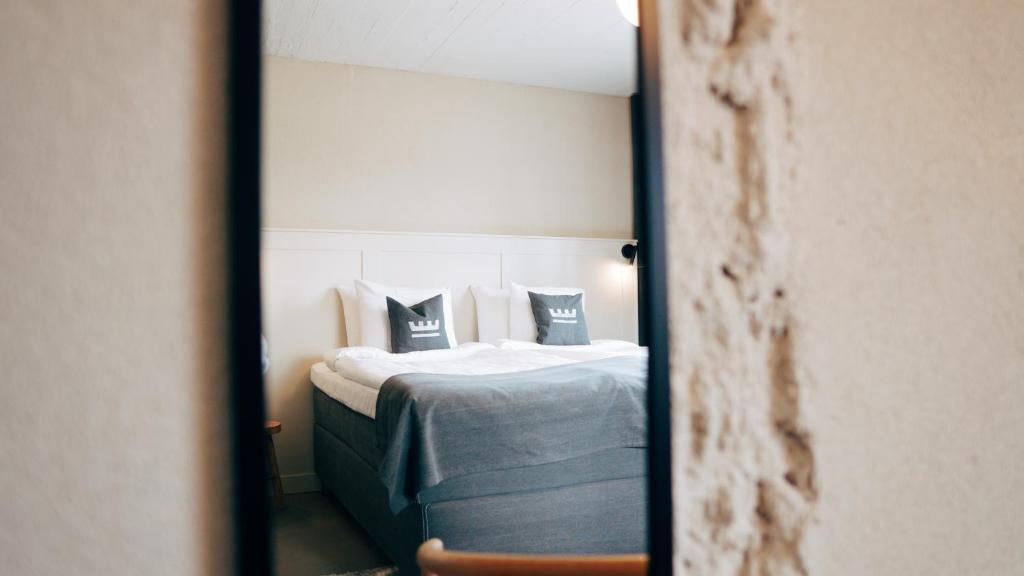 odbicie łóżka z poduszkami w lustrze w obiekcie Loft Hotel Rauma w mieście Rauma