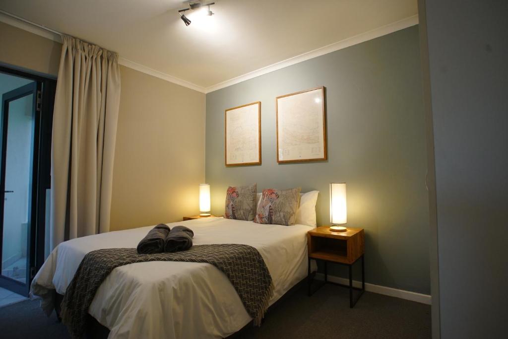 a bedroom with a bed with two lamps on it at Kritzie's Corner - Central and Family Friendly in Cape Town