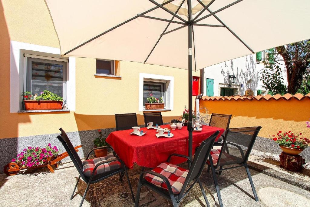 een tafel met een paraplu voor een huis bij Ferienwohnung für 6 Personen ca 75 qm in Krnica, Istrien Bucht von Raša in Krnica