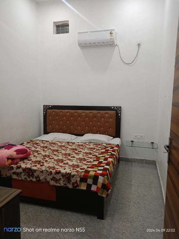 a bedroom with a bed with a quilt on it at Radheshyam bhawan in Govardhan