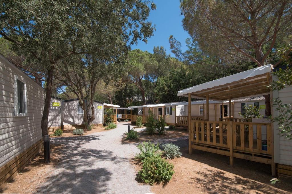 a row of cottages with trees in the background at Camping Santa Elena in Lloret de Mar