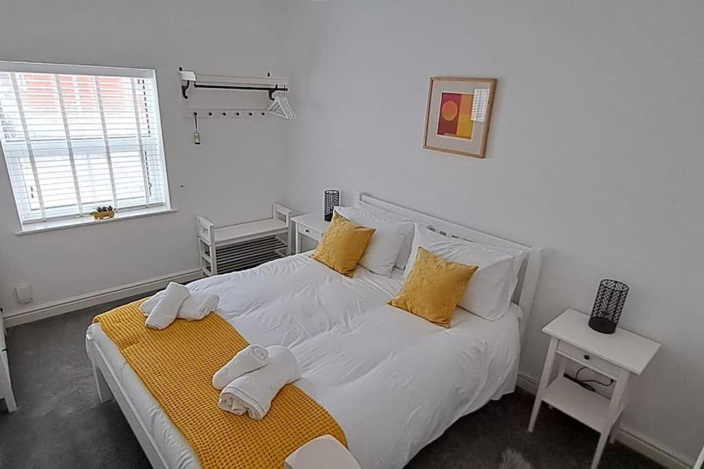 a white bedroom with a bed with towels on it at The Tanners Cottage in Hathern