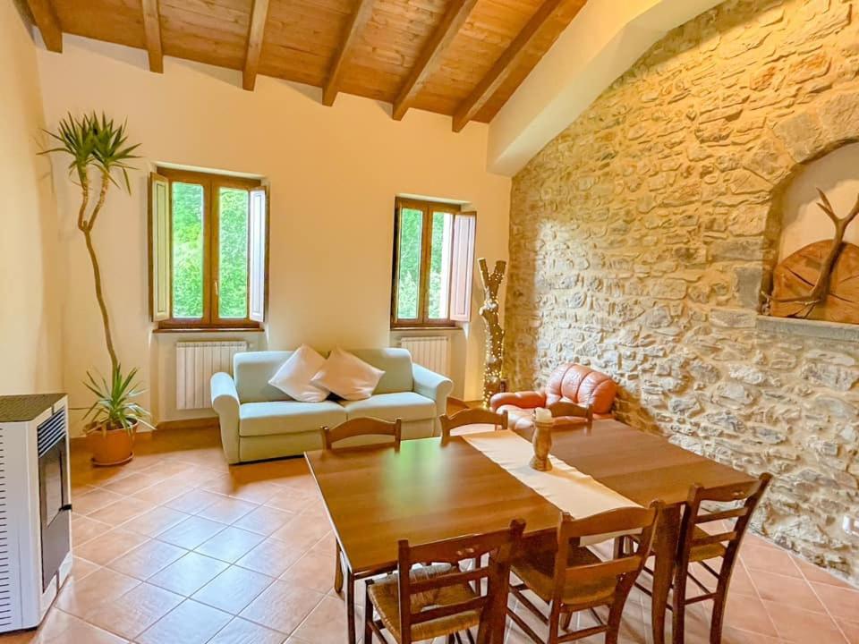 uma sala de estar com uma mesa e um sofá em Agriturismo La Greciola em Gabbiana