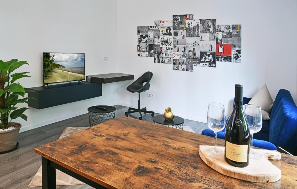 uma garrafa de vinho numa mesa de madeira na sala de estar em Appartement im Grünen, zentral in Biberach em Biberach an der Riß