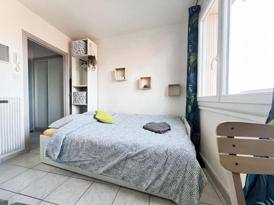 Schlafzimmer mit einem Bett und einem Fenster in der Unterkunft Joli studio vers les thermes, Anatole France -Royat in Royat
