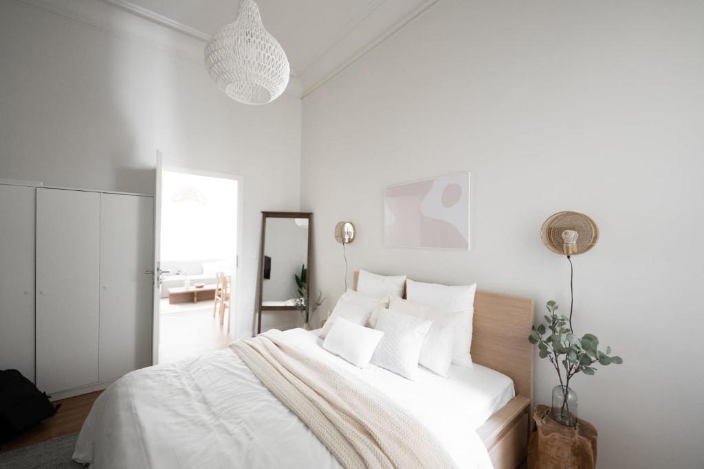 a white bedroom with a large white bed with white pillows at Stockholm Style Designer in Limpertsberg in Luxembourg