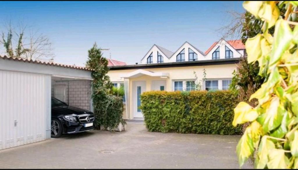 ein Haus mit einem Auto, das in einer Einfahrt geparkt ist in der Unterkunft Little Oasis Near Frankfurt in Neulsenburg