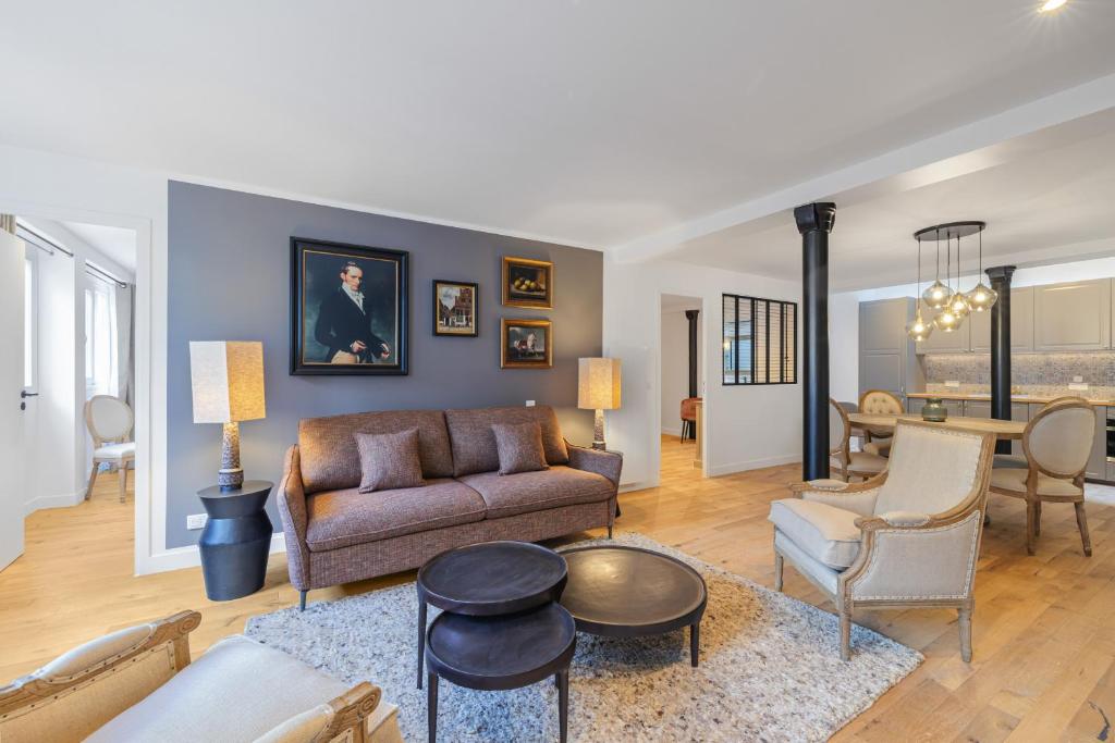 un salon avec un canapé et des chaises dans l'établissement Scarlett, à Paris