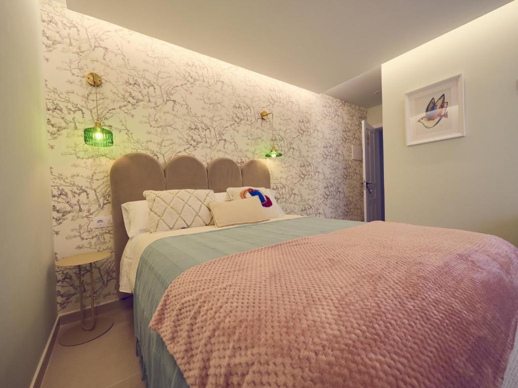 1 dormitorio con 1 cama y una pared con flores en Hostal Casa Maria, en Batán del Puerto