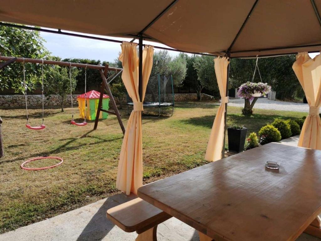 uma mesa de piquenique debaixo de um guarda-chuva num quintal em Ferienwohnung in Privlaka mit Grill, Terrasse und Garten em Privlaka