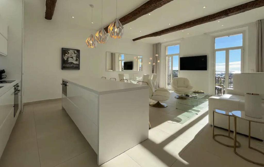 Il comprend une cuisine et un salon avec des murs et des fenêtres blancs. dans l'établissement LUXURY VIEW 2BR IN CANNES, à Cannes