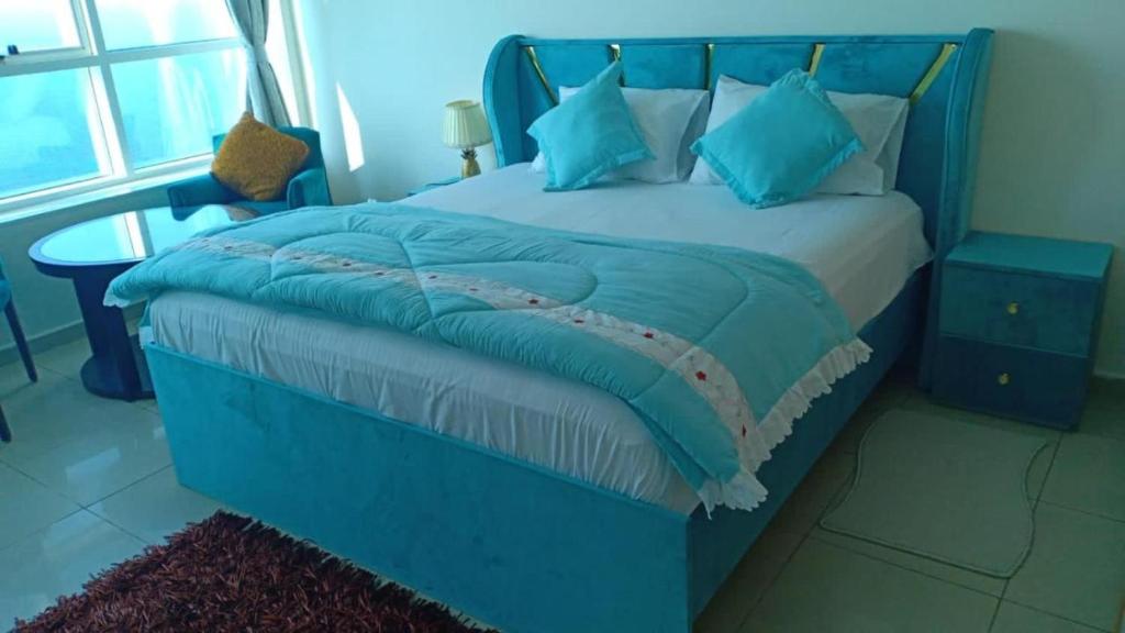a bedroom with a blue bed with blue pillows at 22 R3 Luxury Room in a 4-bedroom apartment with private washroom outside the room ### 22 R3 غرفة فاخرة في شقة 4 غرف نوم مع حمام خاص خارج الغرفة ### in Ajman 
