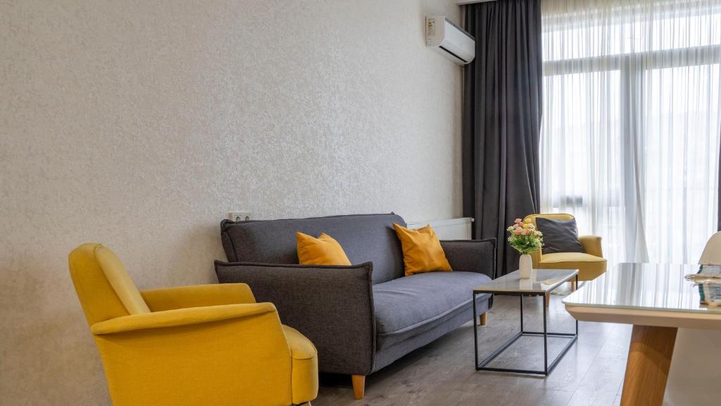 uma sala de estar com um sofá e duas cadeiras em Cozy apartment in the heart of Tbilisi em Tbilisi