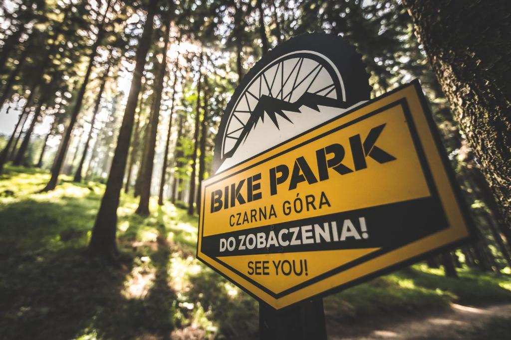 una señal para un parque de bicicletas en un bosque en Apartment BIKE PARK Czarna Góra Resort, en Sienna