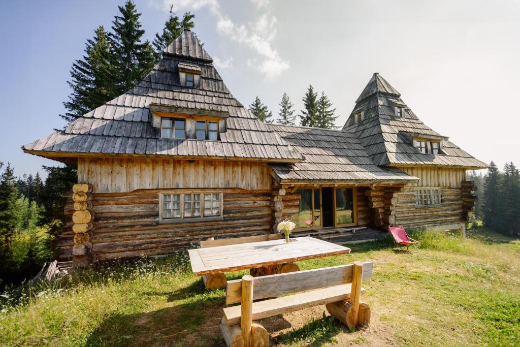 una cabaña de madera con una mesa delante en Nadgora SkyHouse, en Žabljak