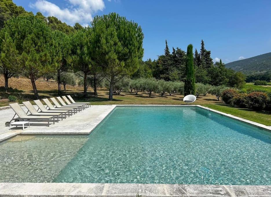 - une piscine avec des chaises longues à côté d'un champ dans l'établissement La Magnanerie, à Ménerbes
